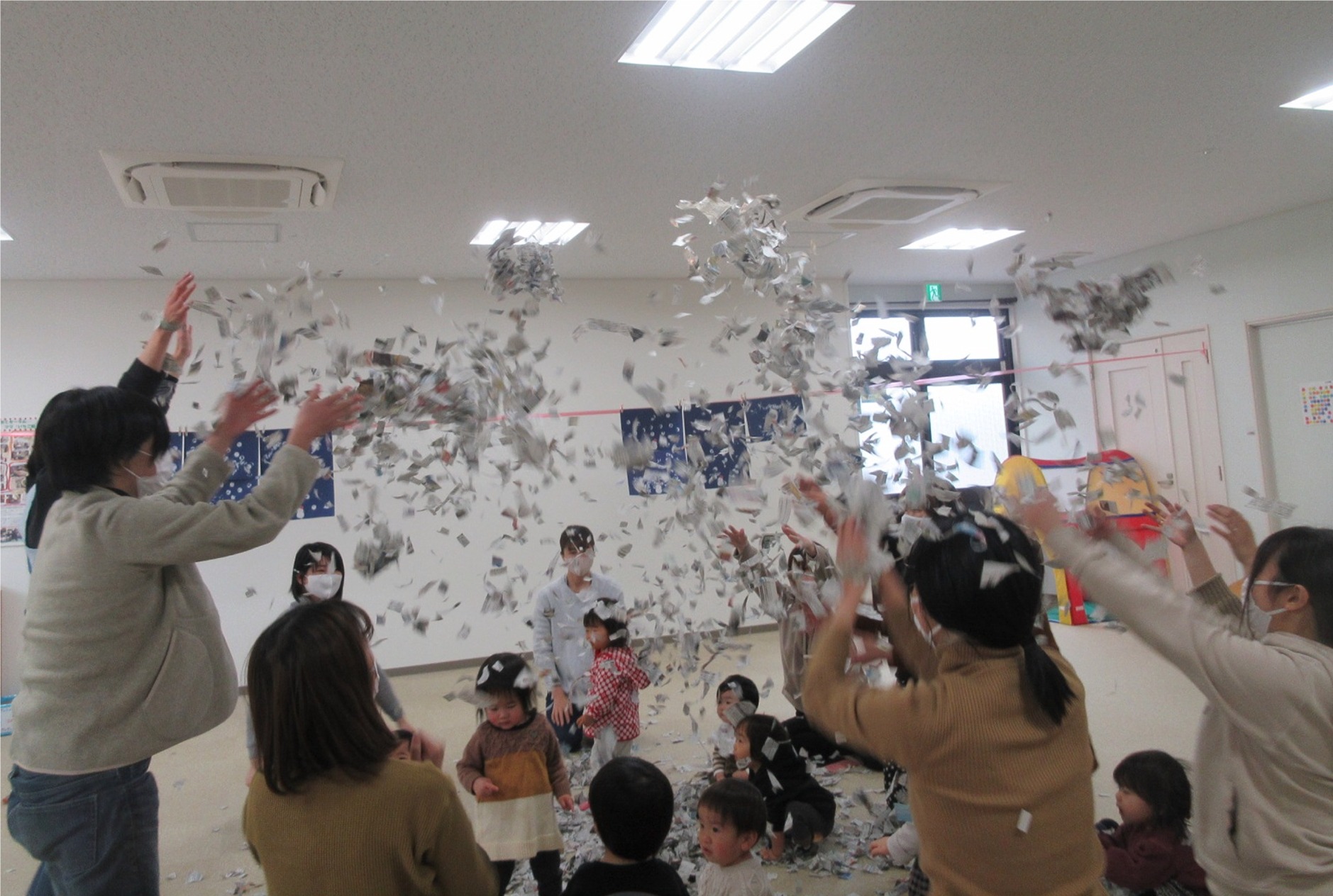 子供の頭上にたくさんの紙吹雪をまいている女性たちの写真