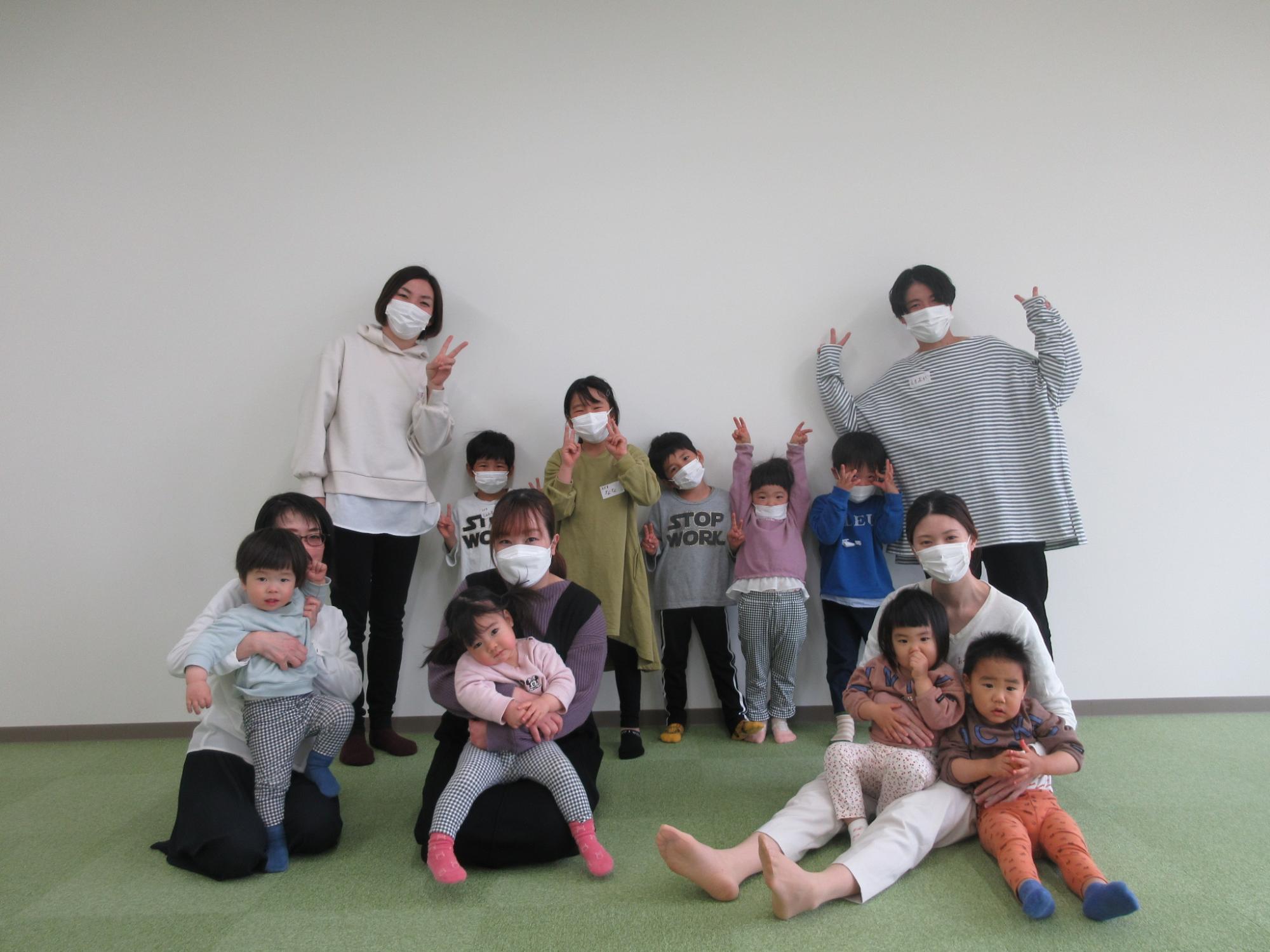 並んでピースをする保護者と子供達の写真