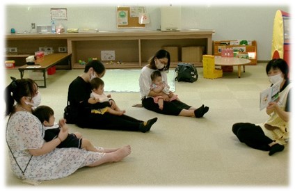 座りながら赤ちゃんを抱っこしている母親が並んでいる写真