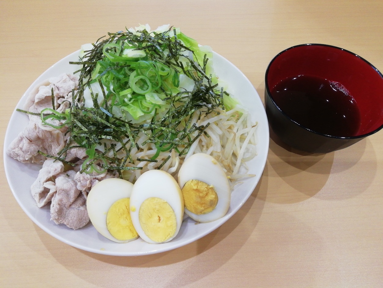 豚肉、卵、もやし、ネギが盛られたお皿とつゆが入れられたお椀が並べられている写真