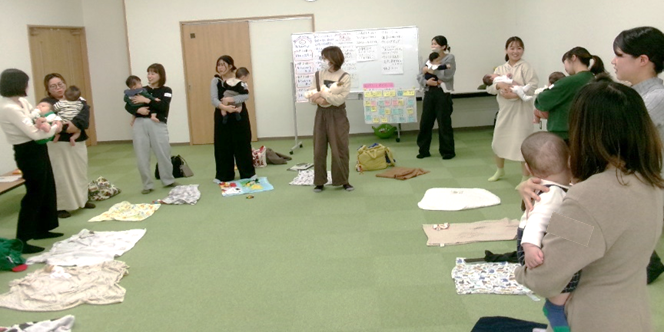 たくさんの女性たちが赤ちゃんを抱っこしながら立っている写真