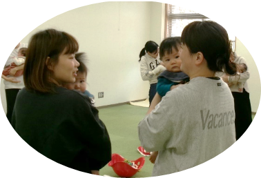 女性二人が赤ちゃんを抱っこしながら会話をしている写真