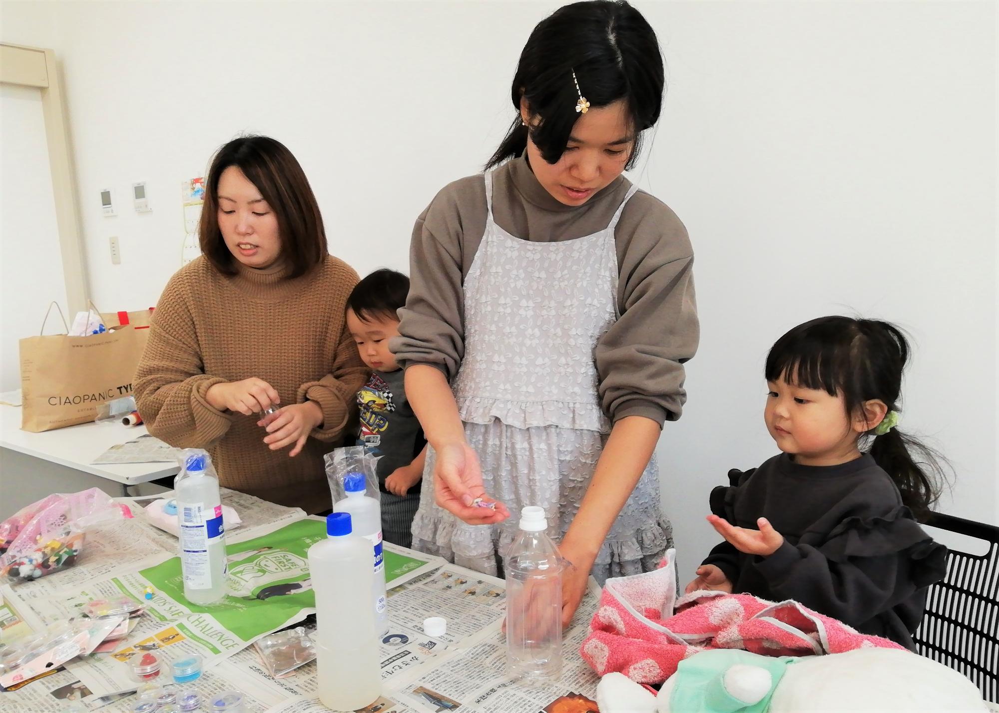 新聞紙を引いたテーブルで工作をしている親子たちの写真