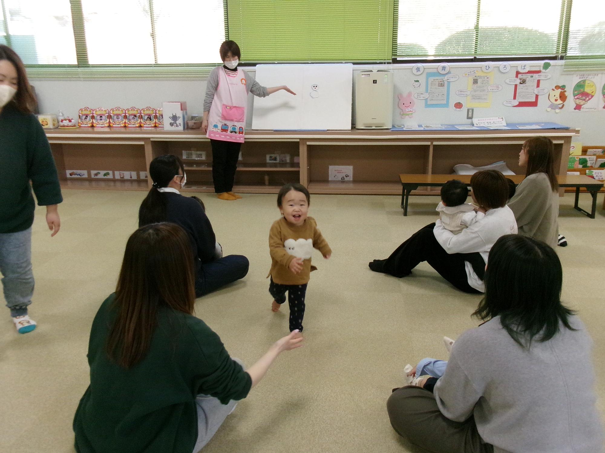雪だるまの登場を見ている親子