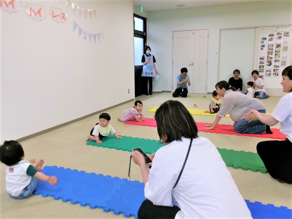 ハイハイレーススタート前の赤ちゃんの様子を見守る母の様子