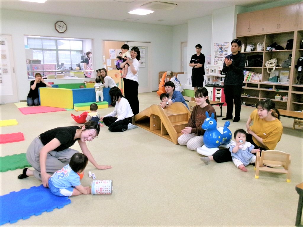 ハイハイをしている赤ちゃんを応援する参加者の様子