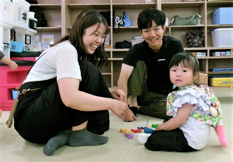 人形で遊ぶ子供を見守る父母