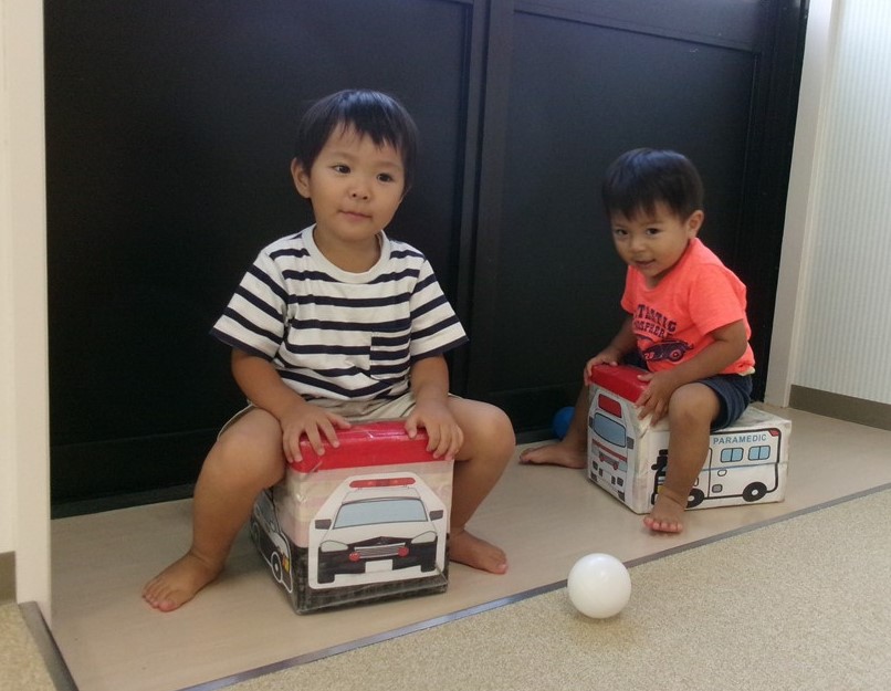 車のおもちゃにのる子どもたち