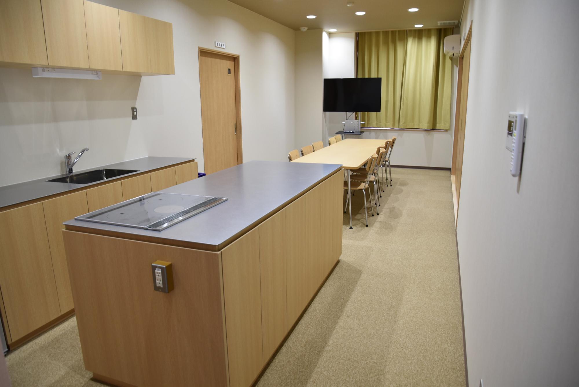 キッチンシンクや調理台が設置された縦長の部屋の写真