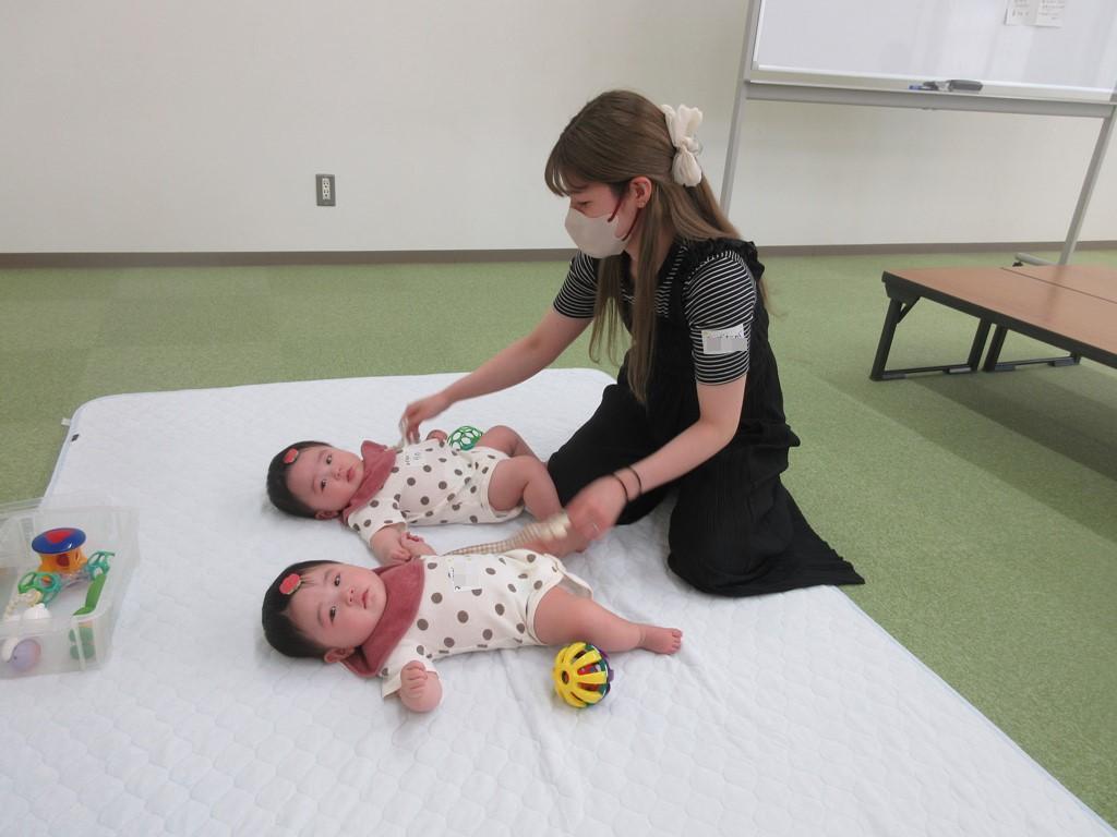 双子の子どもをあやす母の様子
