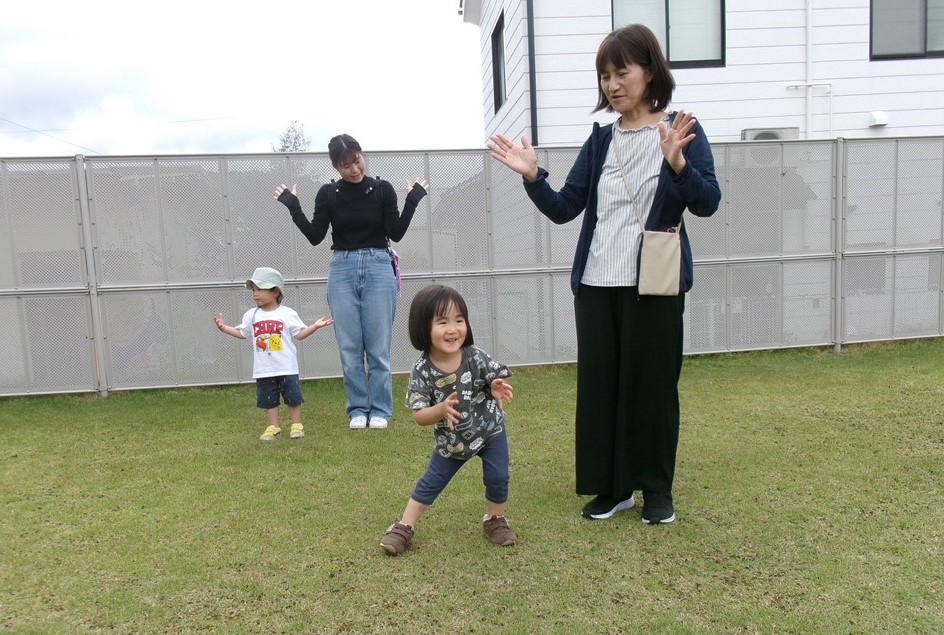 芝生広場で踊る親子の様子