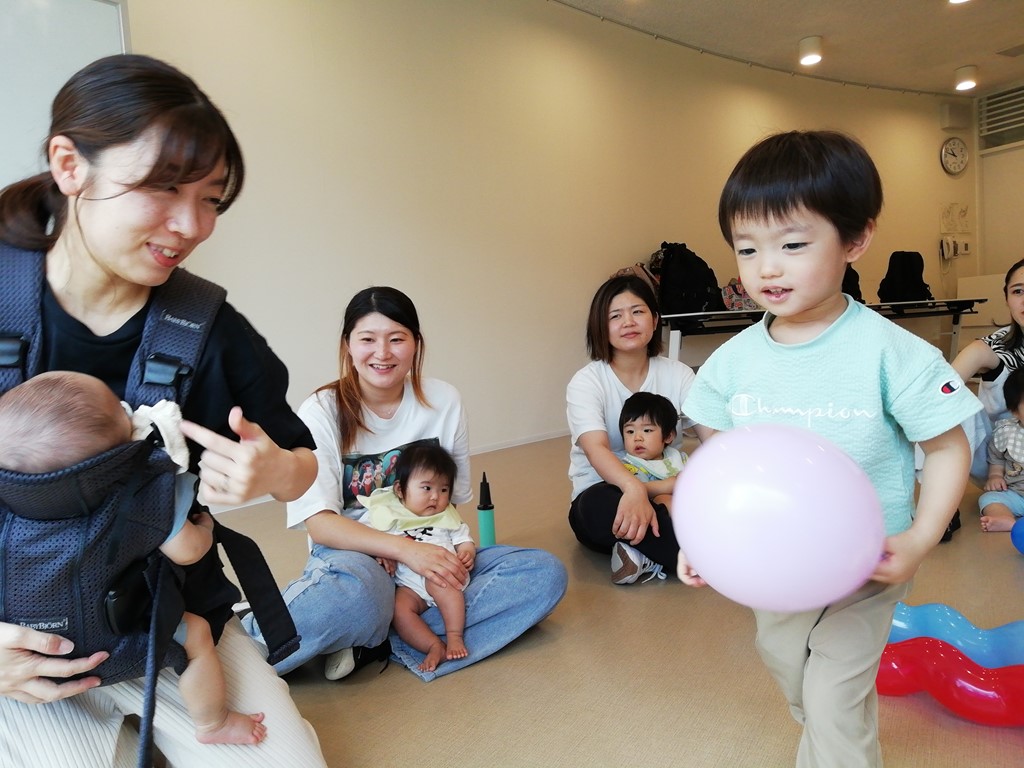 6月ののびのびサークルで風船を赤ちゃんに見せるお兄ちゃんの様子