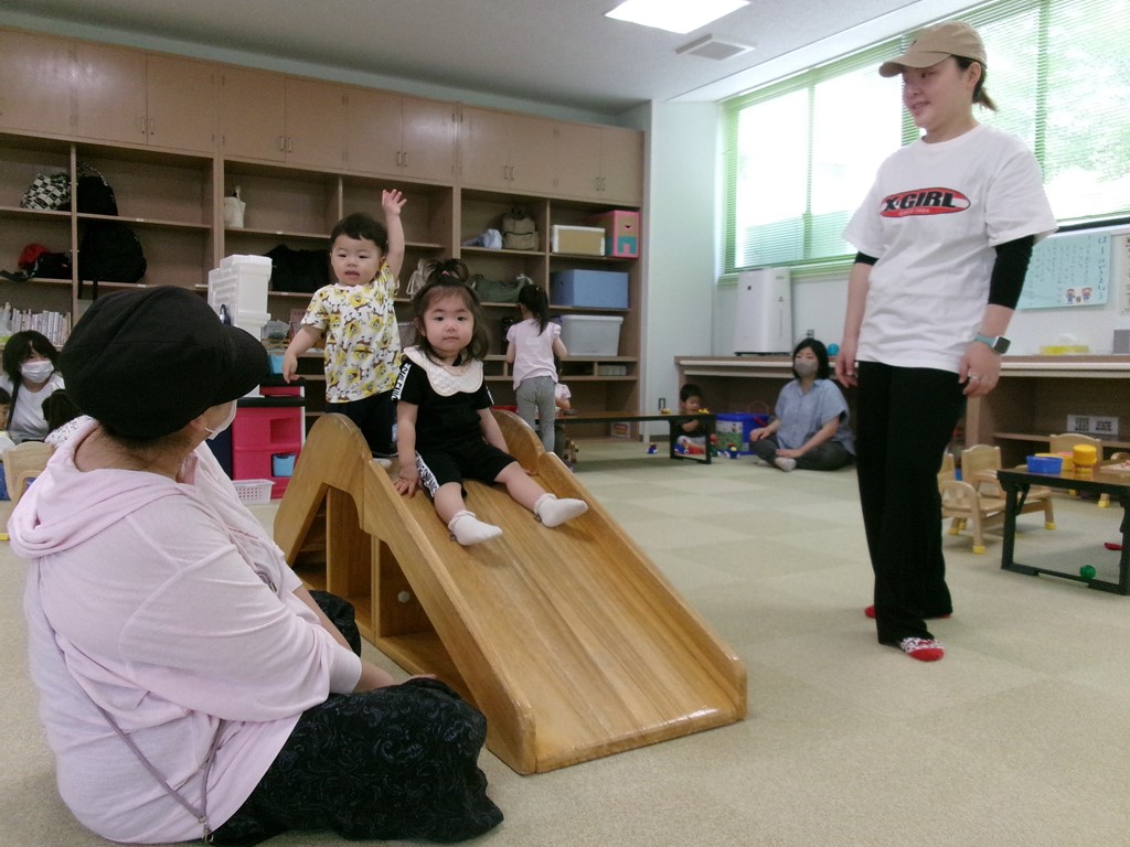滑り台で遊ぶ子供を見守る母の様子