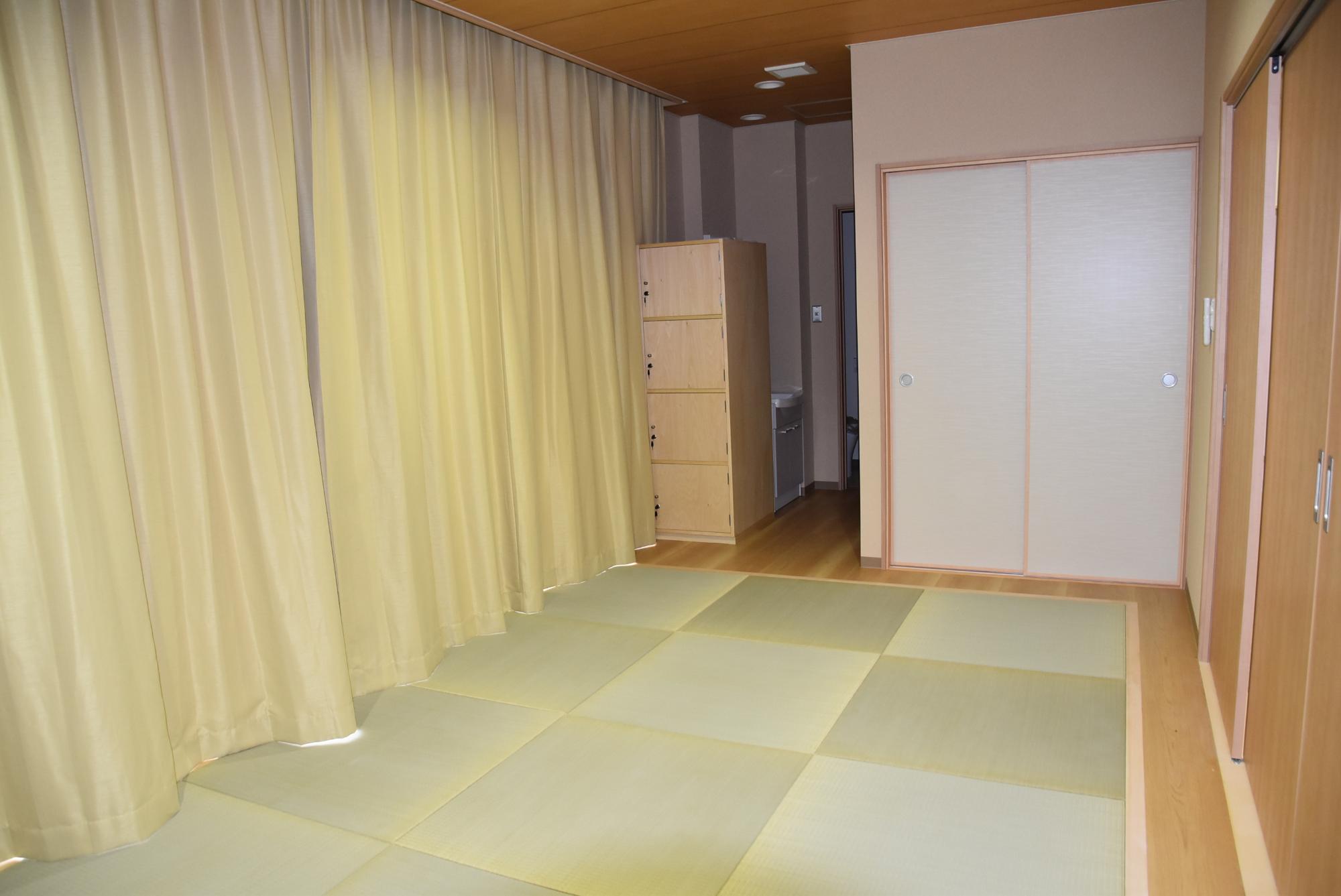 片側の壁にカーテンがかけられている部屋の写真