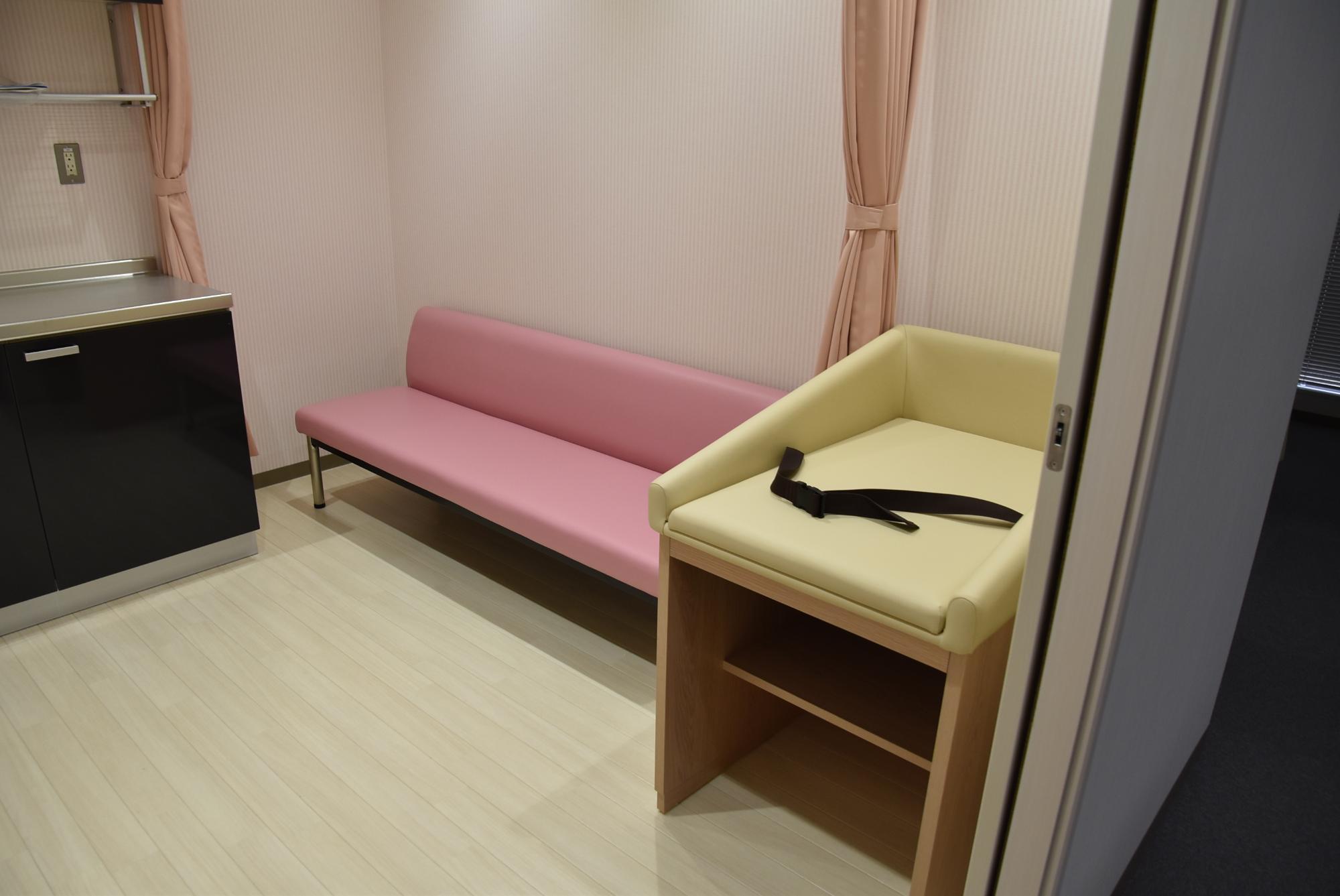 壁際におむつ交換台とソファが設置されている部屋の写真