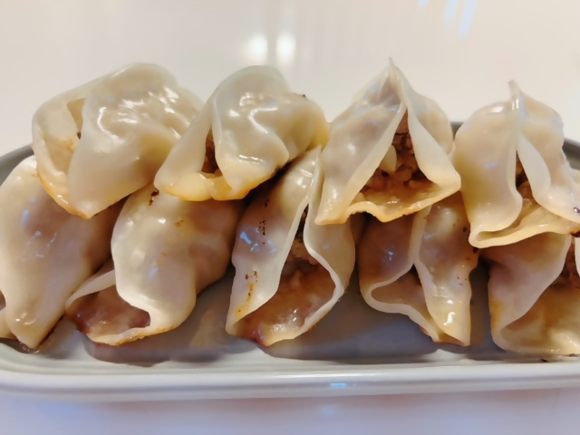 2段に積まれた餃子が皿に置かれている写真