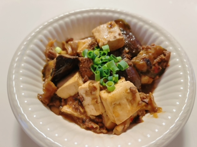 ネギの乗った麻婆豆腐が盛られた皿の写真