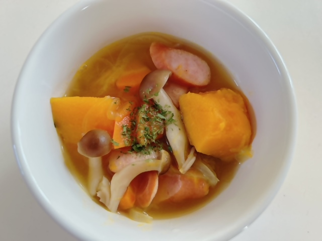 お皿にきのこ・野菜・ソーセージのスープが入れられている写真