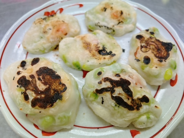 枝豆の入ったもちの焼き物が皿に並べられている写真