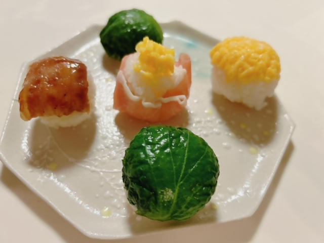 ハム・野菜・肉・たまごの丸い寿司が十字に5つ並んだ皿の写真