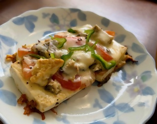 豆腐にピーマン・トマト・チーズが乗った料理が皿に置かれている写真