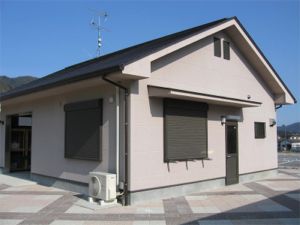 黒い屋根に白い壁の倉庫の写真