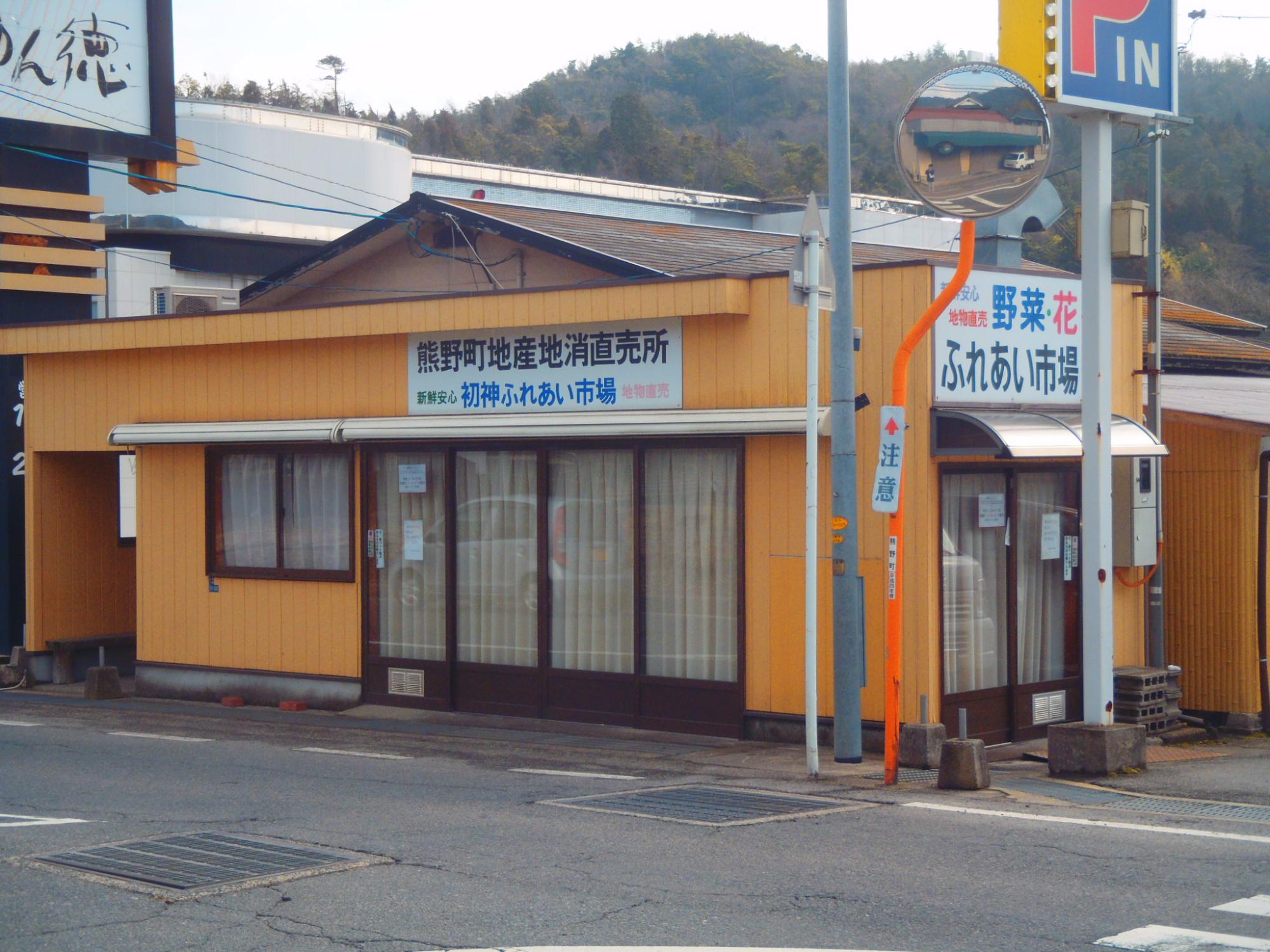 橙色の壁でふれあい市場の看板が掲げられた初神ふれあい市場の外観の写真