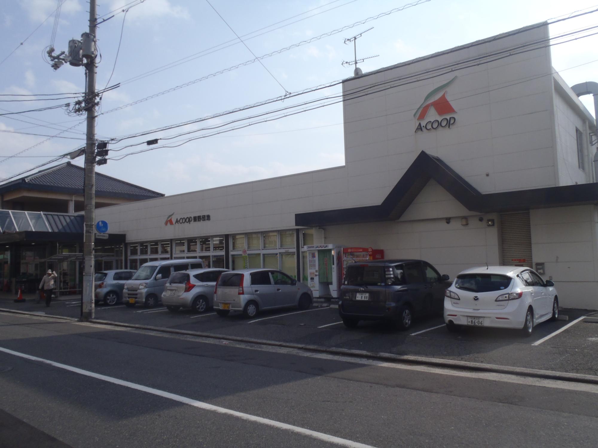 前に駐車場があるAコープ熊野団地店の外観の写真