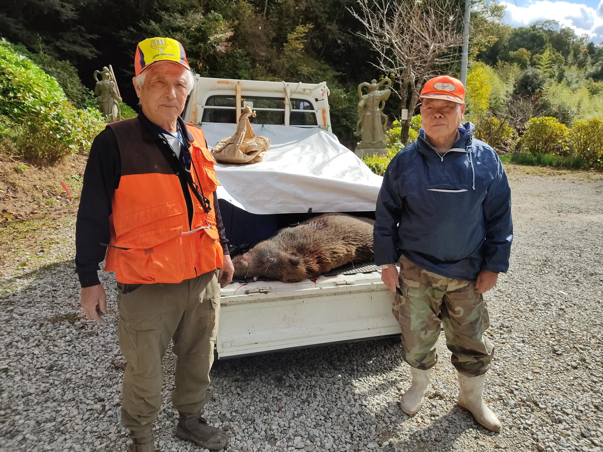 熊野町鳥獣被害対策実施隊とトラックの荷台に載せられたイノシシの写真