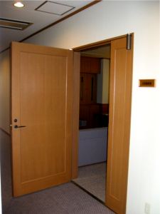 茶色い扉が開いて室内の一部が見えている写真