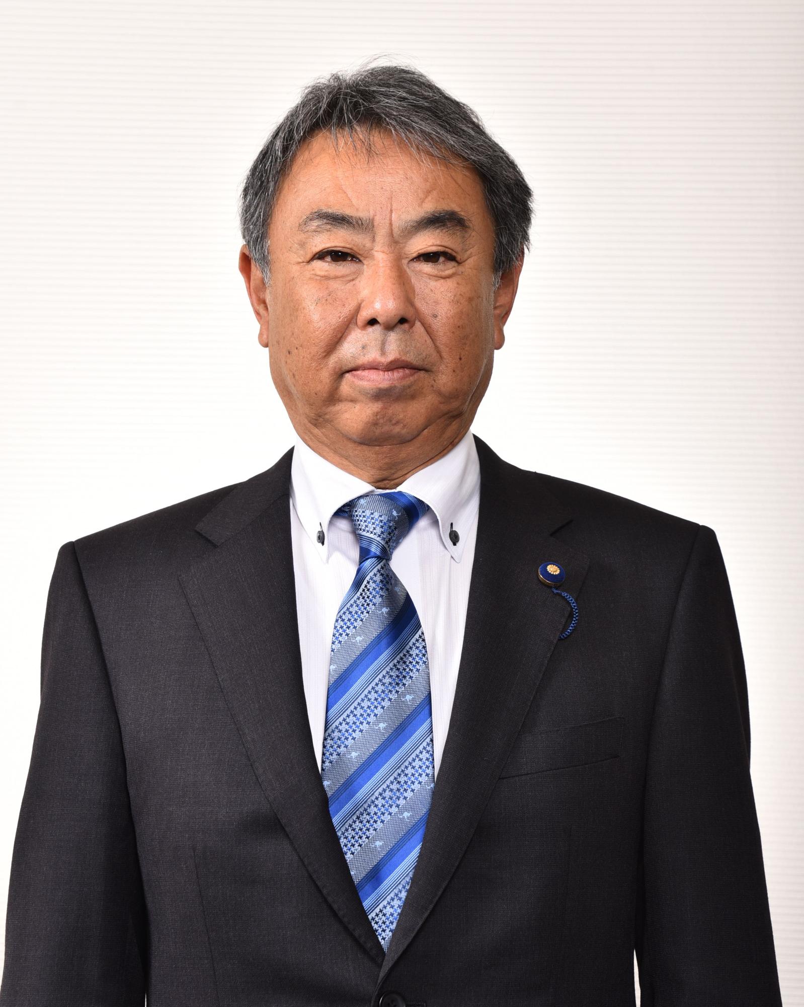 暗い水色と青色のストライプ模様をしたネクタイを付けている男性の写真