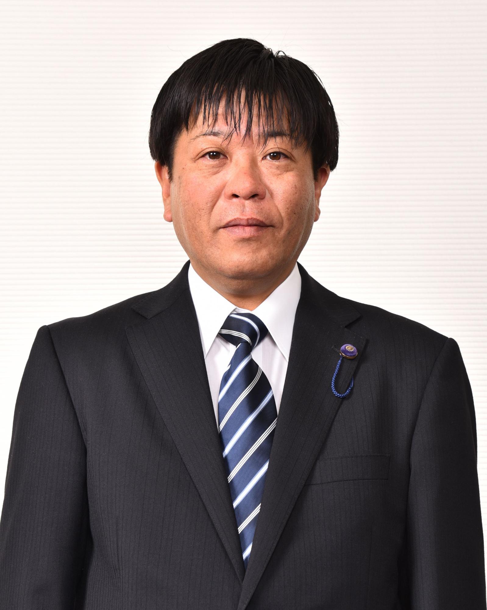 青と白のストライプ模様をしたネクタイを付けている男性の写真