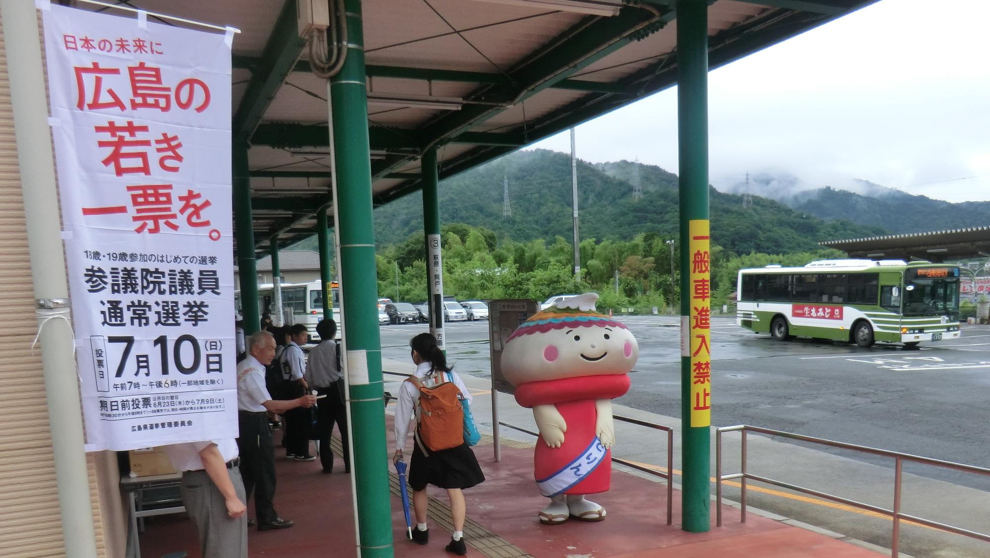 外でマスコットキャラクターの着ぐるみを着た方と男性が選挙活動を行っている写真