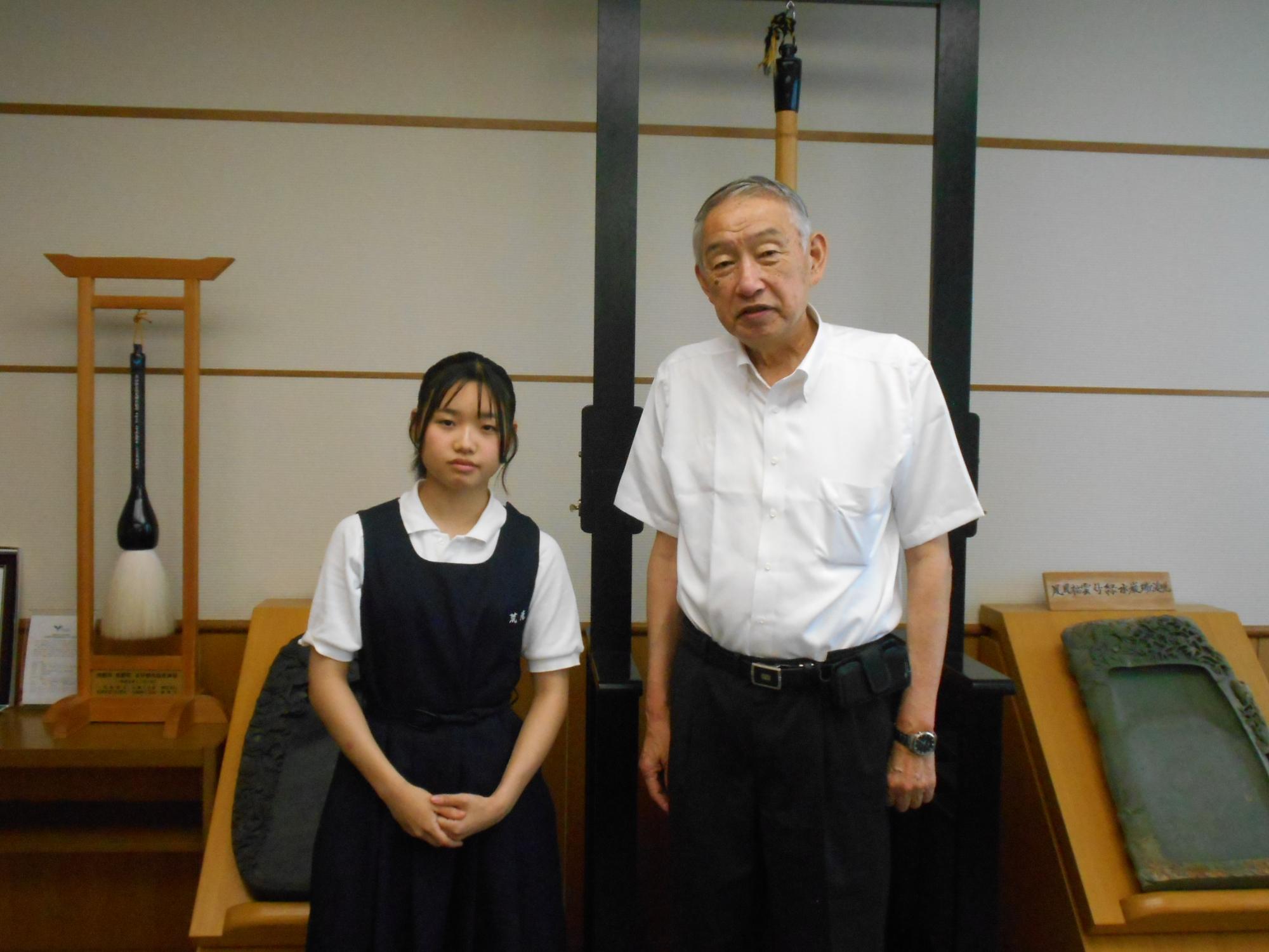 熊野町庁舎で熊野町長といっしょに記念撮影に臨む荒滝渚菜さんの写真