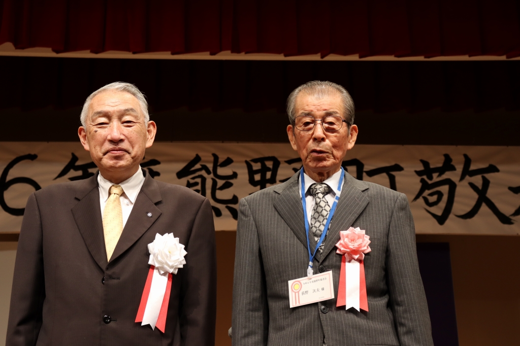 熊野町長といっしょに記念撮影に臨むスーツ姿の男性の写真