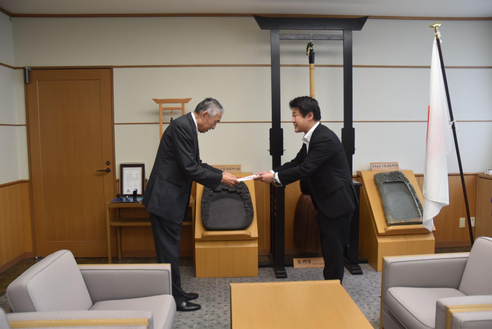 明治安田生命保険相互会社広島支社の男性から目録を受け取る熊野町長の写真