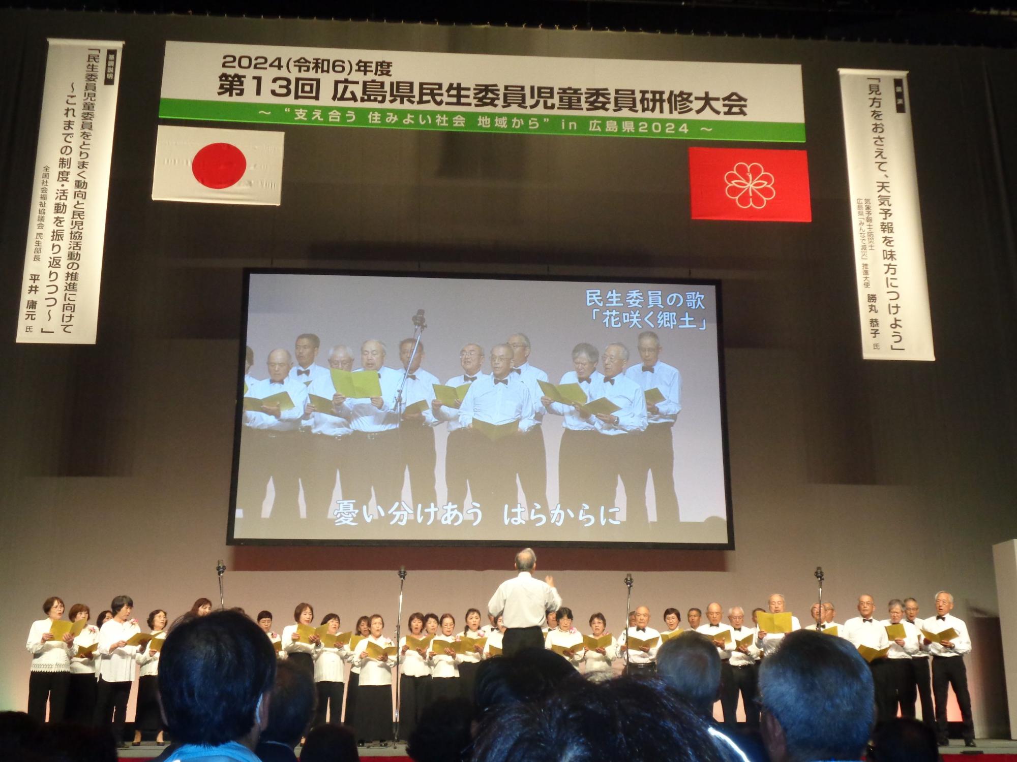 壇上で民生委員の歌を歌唱する熊野町民生委員児童委員の皆さんの写真