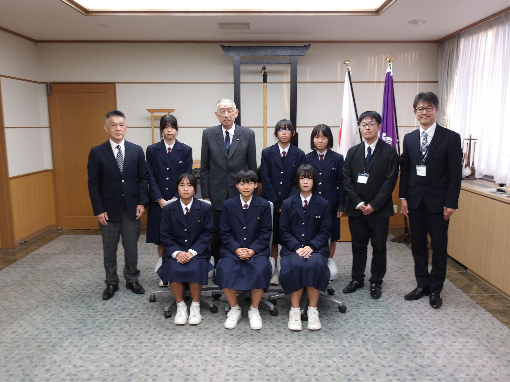 熊野町庁舎の一室で熊野町長との記念撮影に臨む熊野東中学校陸上部長距離女子の皆さんの写真