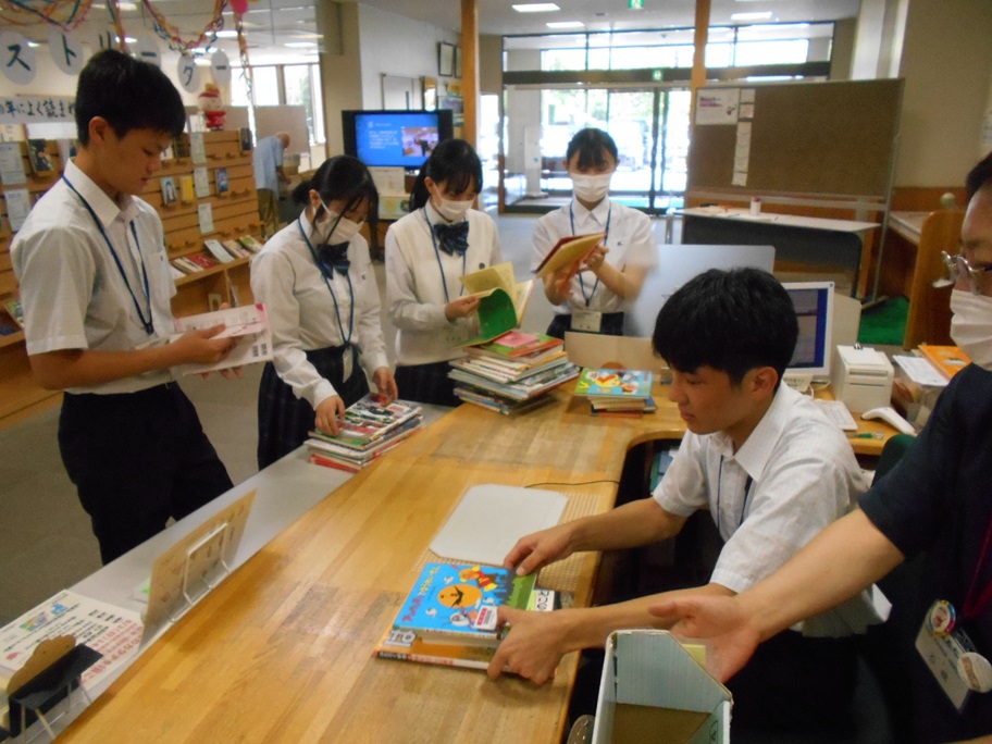 図書館で貸し出し図書の返却業務の実務を体験している高校生たちの写真
