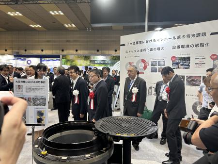 式典会場でマンホールの展示物を視察している熊野町長の写真