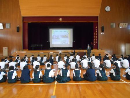 体育館で座っている生徒たちの写真