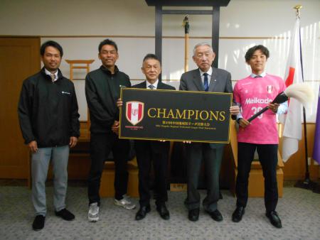 熊野の大筆やチームの看板を手にし熊野町長との記念撮影に臨むヴァリアモーレ安芸の方々の写真