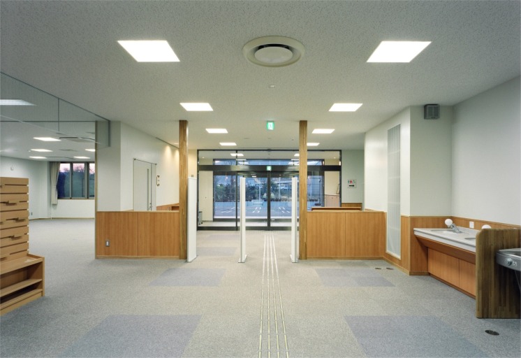 貸し出し手続き確認のためのゲートの奥に正面玄関があるエントランスの写真