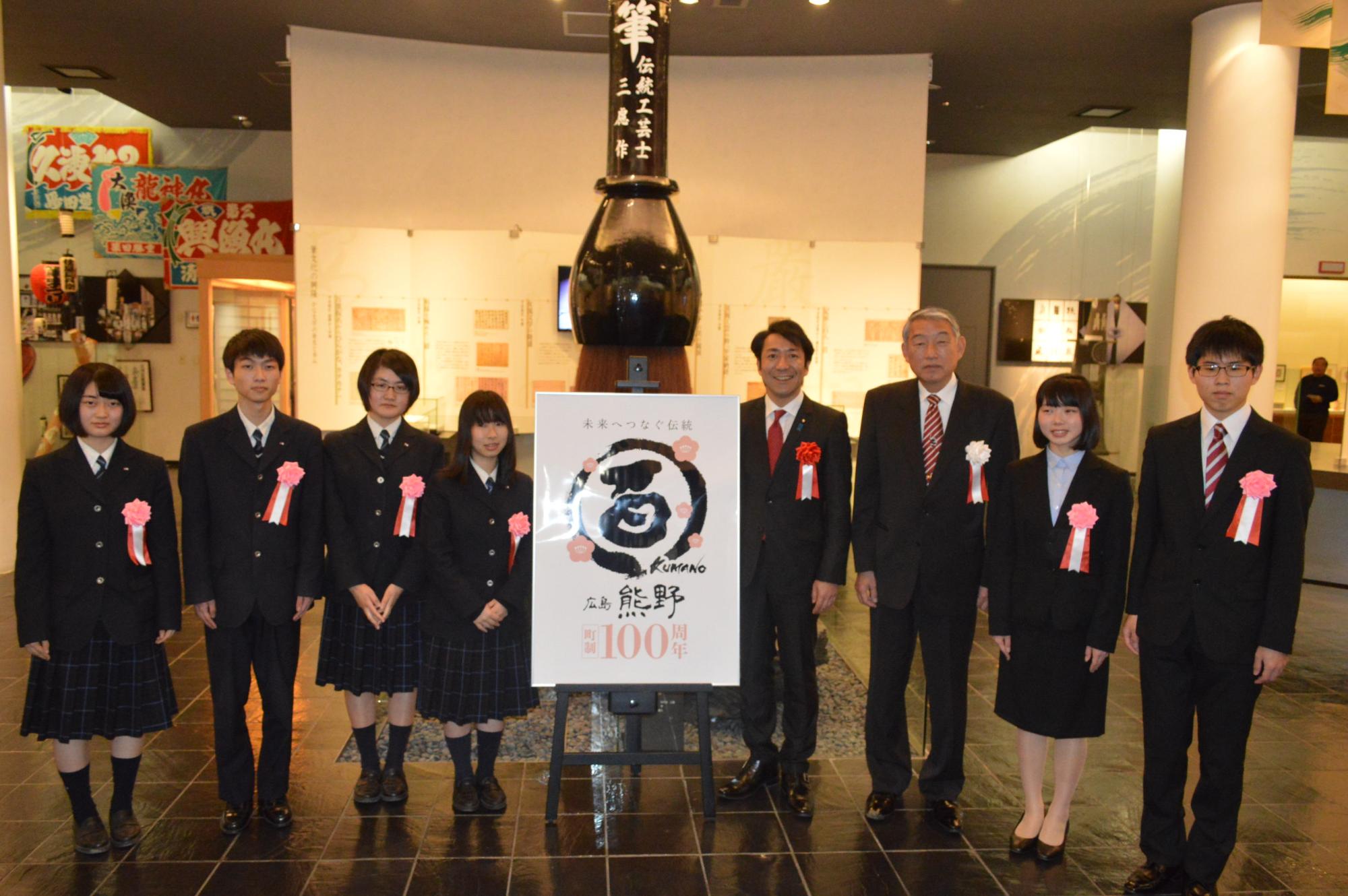 町制施行100周年記念事業ロゴマーク原案を制作して作品賞を受賞した生徒たちと三村町長が並んで撮影された記念写真