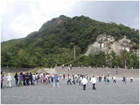 熊野古道にある花の窟神社の行事で、大勢の参拝者が岩から伸びている長い綱を引いている写真