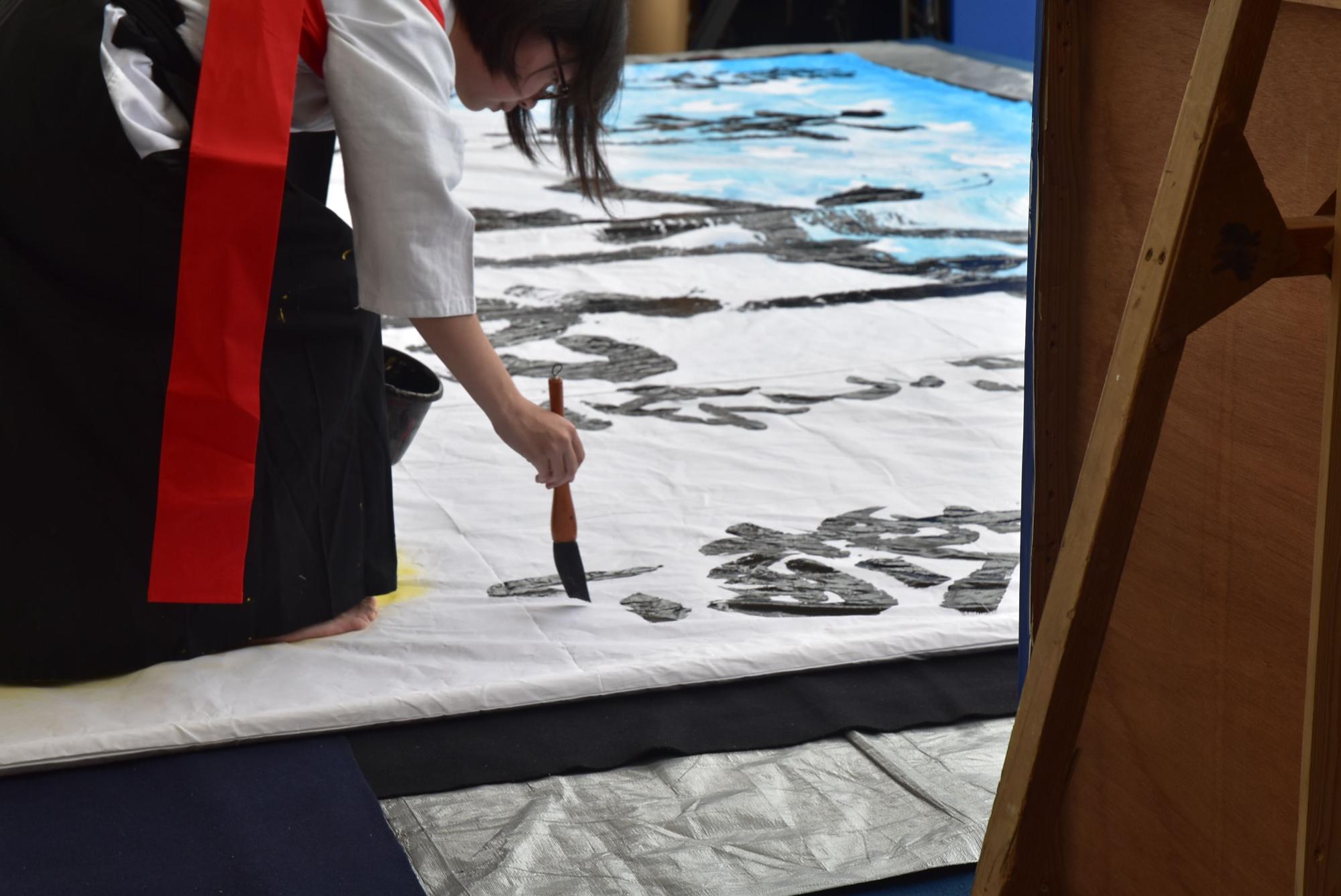 「みんな輪になり」の部分を書き上げている書道部員の写真