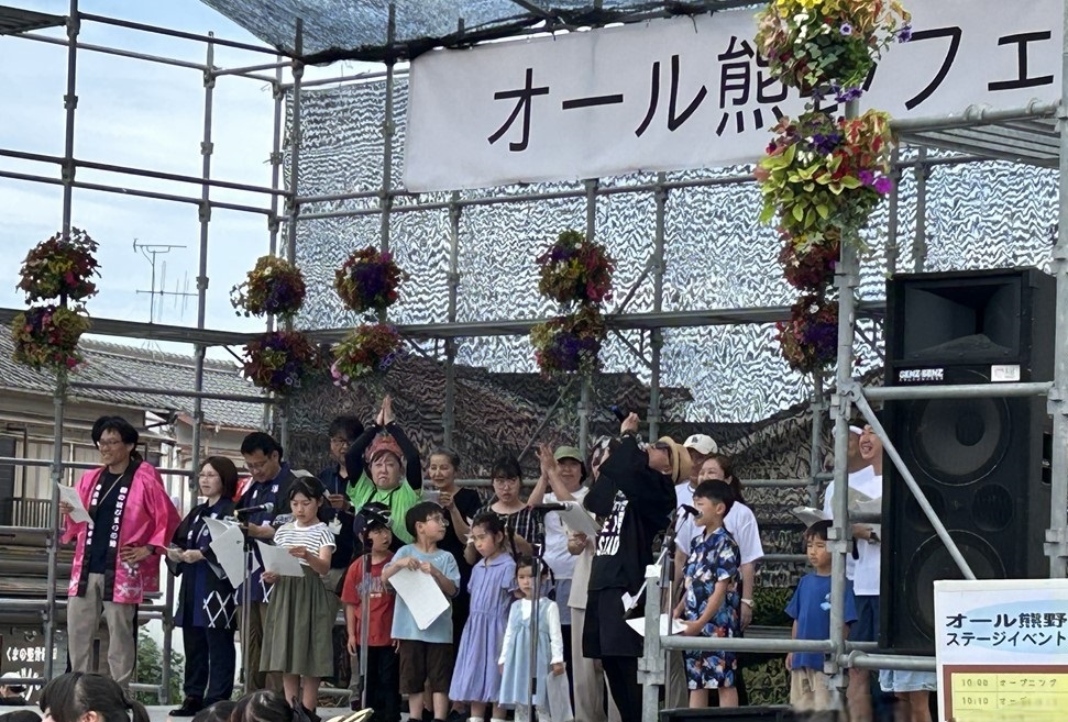 ステージ上で集められた参加者で合唱をしている写真