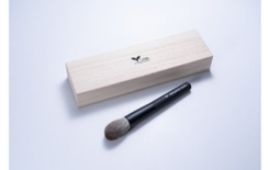 箱と一本のチークブラシが写るイメージ写真