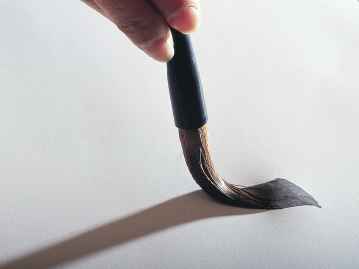 和紙に筆で一筆書いている写真