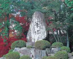 森の中で佇む筆塚と刻印された石碑の写真